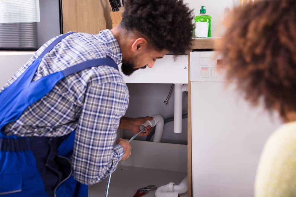 male plumber cleaning clogged pipes