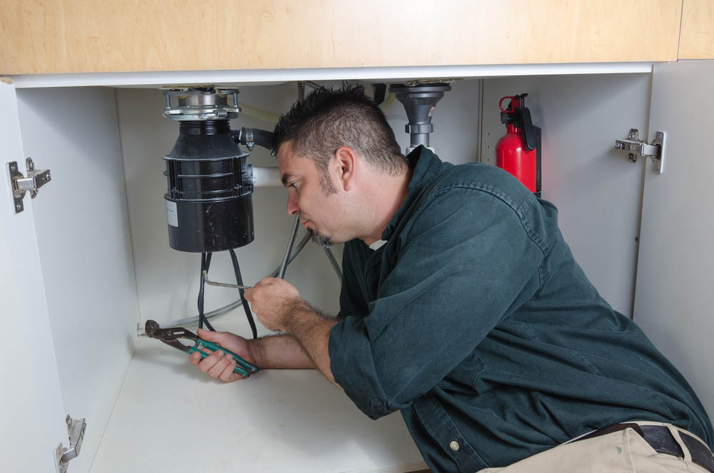 plumber repairing a garbage disposal