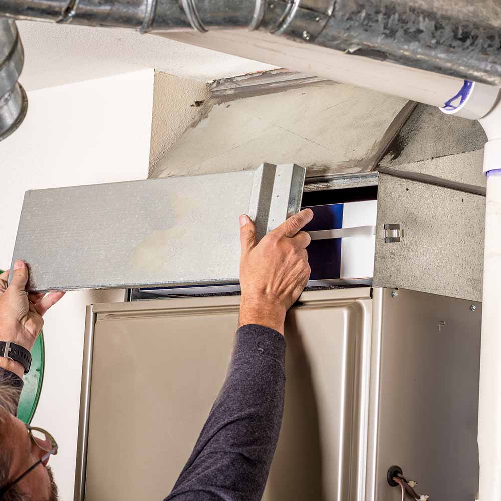 technician inspecting a furnace heating system Cleveland, OH technician inspecting a furnace heating system Cleveland, OH
