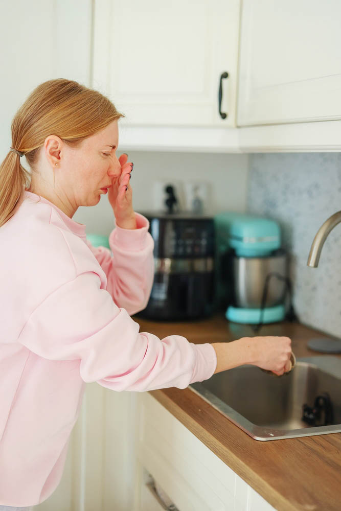 homeowner checking a smelly drain