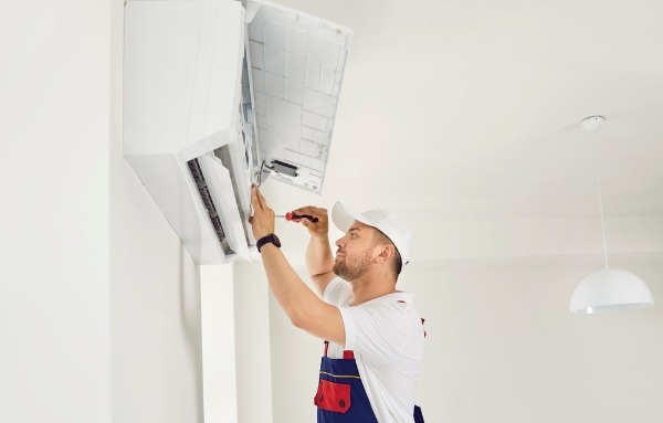 technician servicing indoor ac wall unit