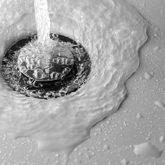 Water,Drains,Into,The,Hole,Of,White,Sink,In,The water drains into the hole of white sink in the bathroom